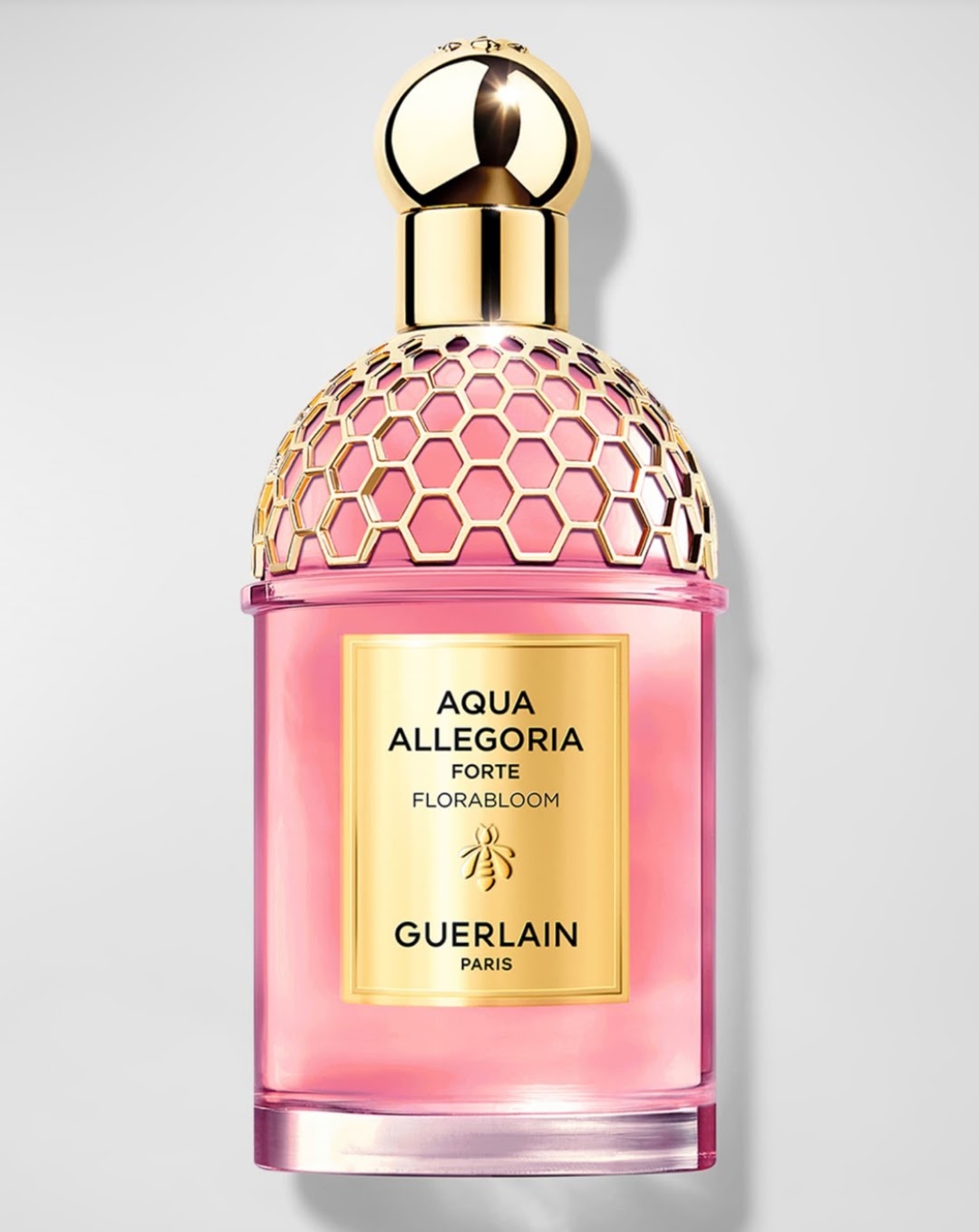 Guerlain Aqua Allegoria Forte Florabloom perfume bottle with a pink glass body, gold hexagonal cap, and gold label on a light gray background.