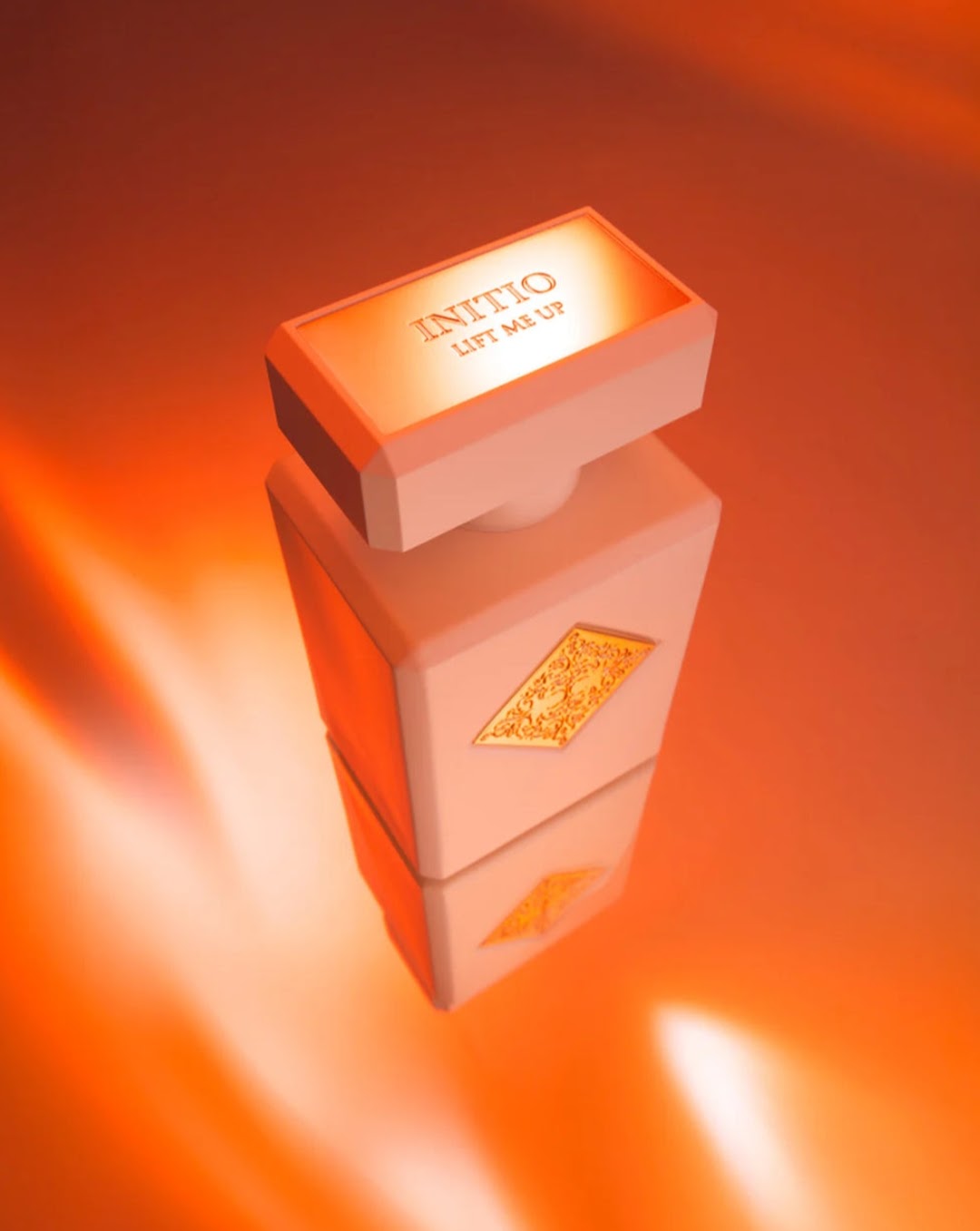 A perfume bottle with a rectangular cap and rounded edges, shown floating on a reflective surface against a glowing orange background. The cap is engraved with the brand name 'INITIO' and the scent 'LIFT ME UP'.