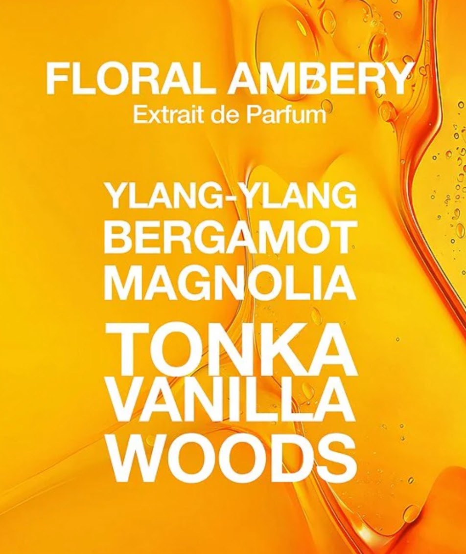 A perfume scent list graphic with the title 'FLORAL AMBERY Extrait de Parfum' in white text over a bright yellow-orange abstract liquid background, listing notes: YLANG-YLANG, BERGAMOT, MAGNOLIA, TONKA, VANILLA, WOODS.