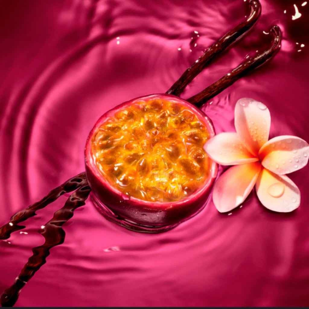 A halved passion fruit with bright orange-yellow pulp floating in vivid magenta liquid, styled with vanilla beans and a white-and-pink flower on a glossy pink background.