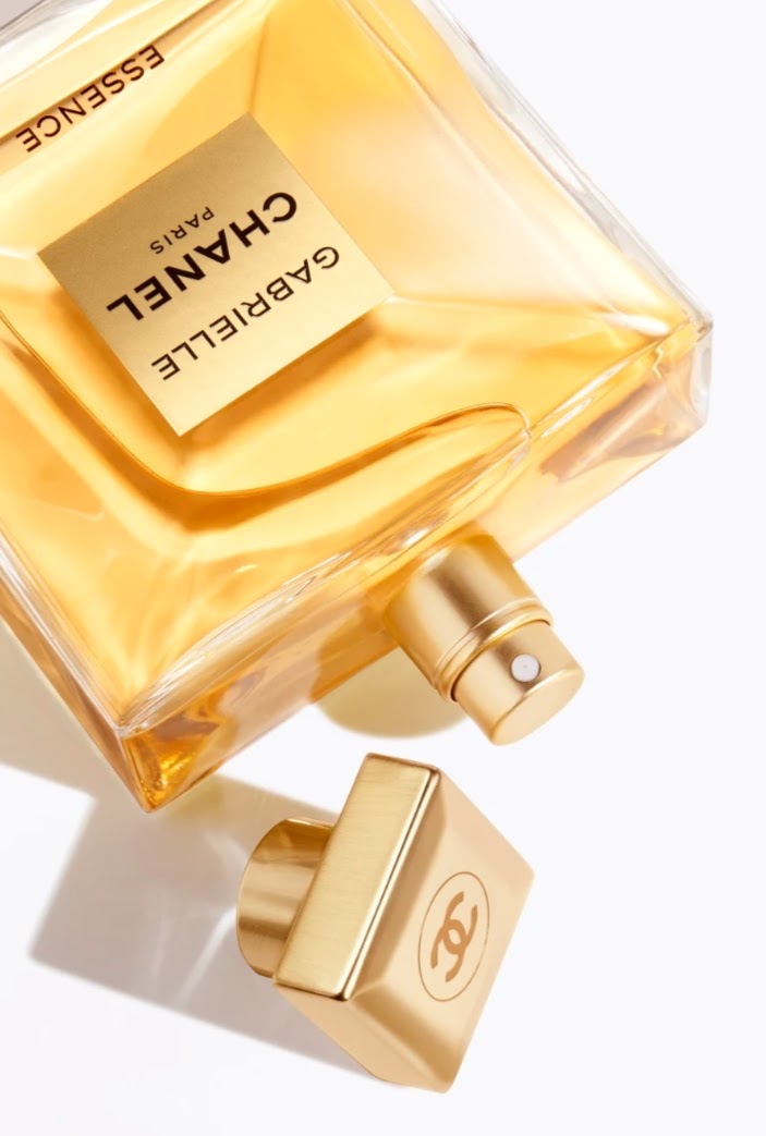 Chanel Gabrielle Essence perfume bottle in a warm golden yellow color with a matching gold cap, shown on a clean white background.