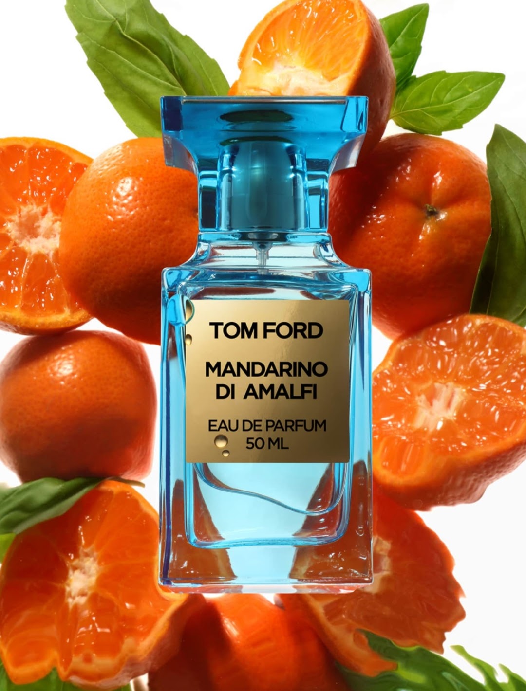 Tom Ford Mandarino Di Amalfi Eau de Parfum bottle, featuring a translucent blue glass body and a beige label, centered against a background of fresh oranges and mint leaves.